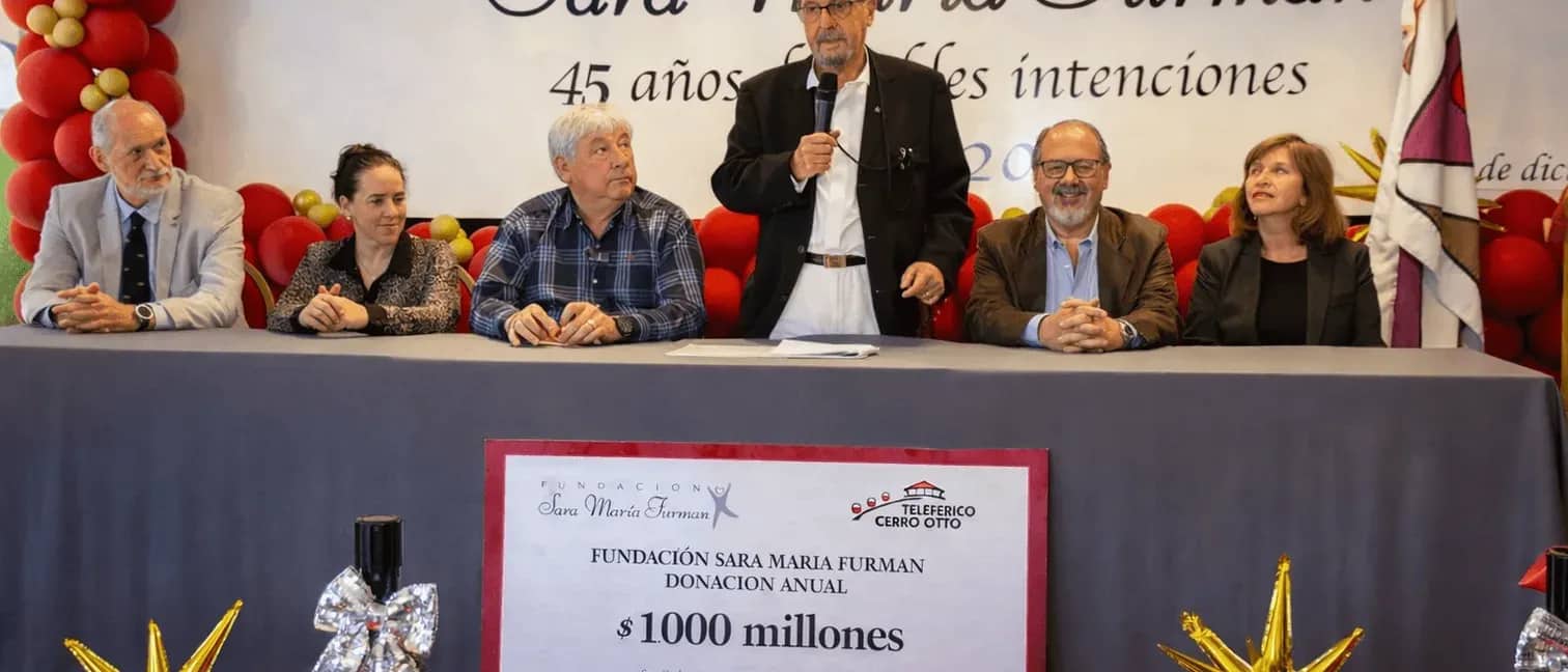 Members of the foundation giving a speech with a sign showing the donation made for a total amount of 1 million Argentine pesos