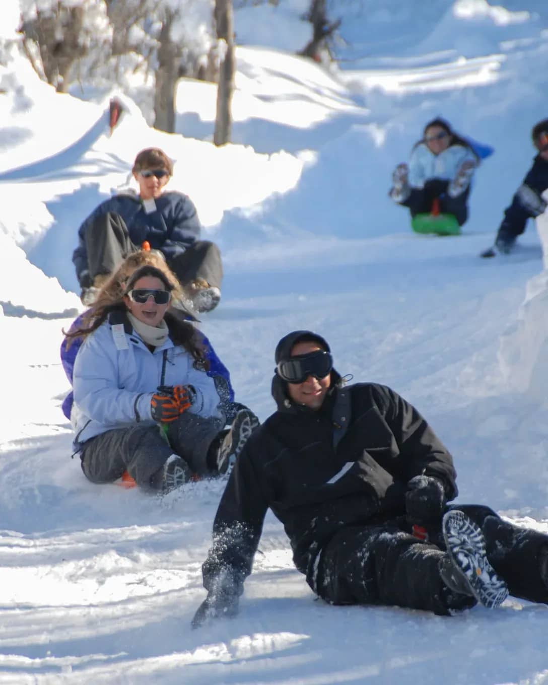 Close-up of people launching themselves headfirst down the toboggan run at speed