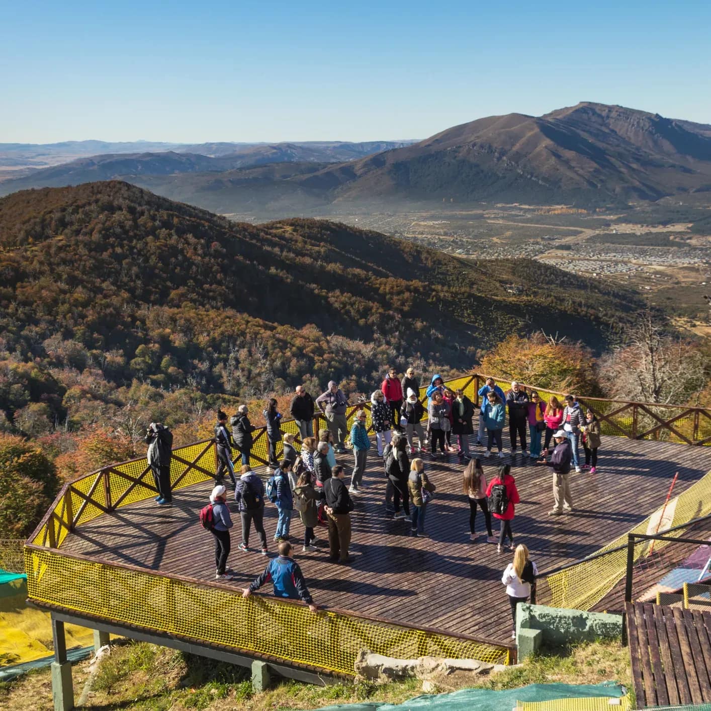 Terraço panorâmico com pessoas admirando a paisagem da montanha.