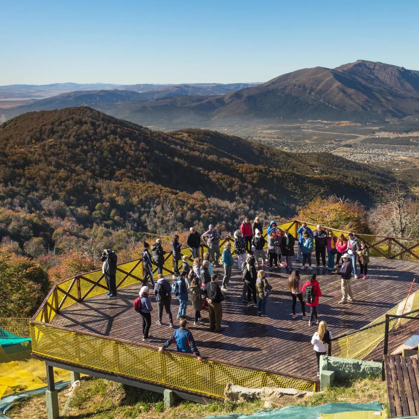 Panoramic view of a group of people marveling at the natural surroundings of mountains and forest