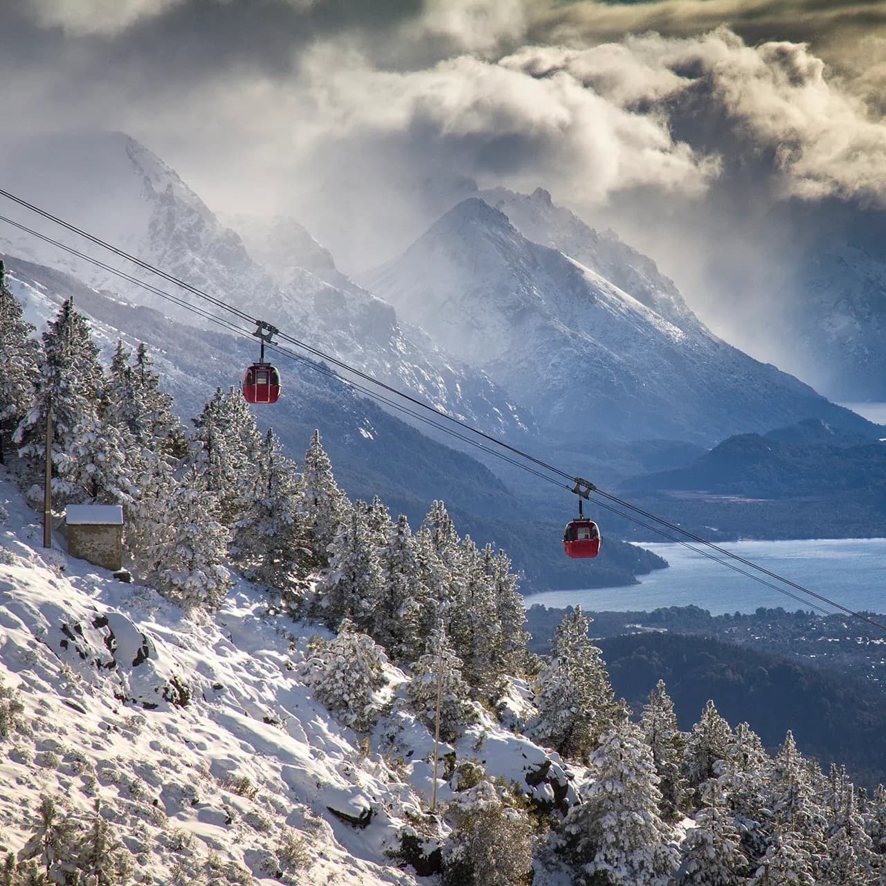 Two cable cars in motion with Lake Nahuel Huapi in the background