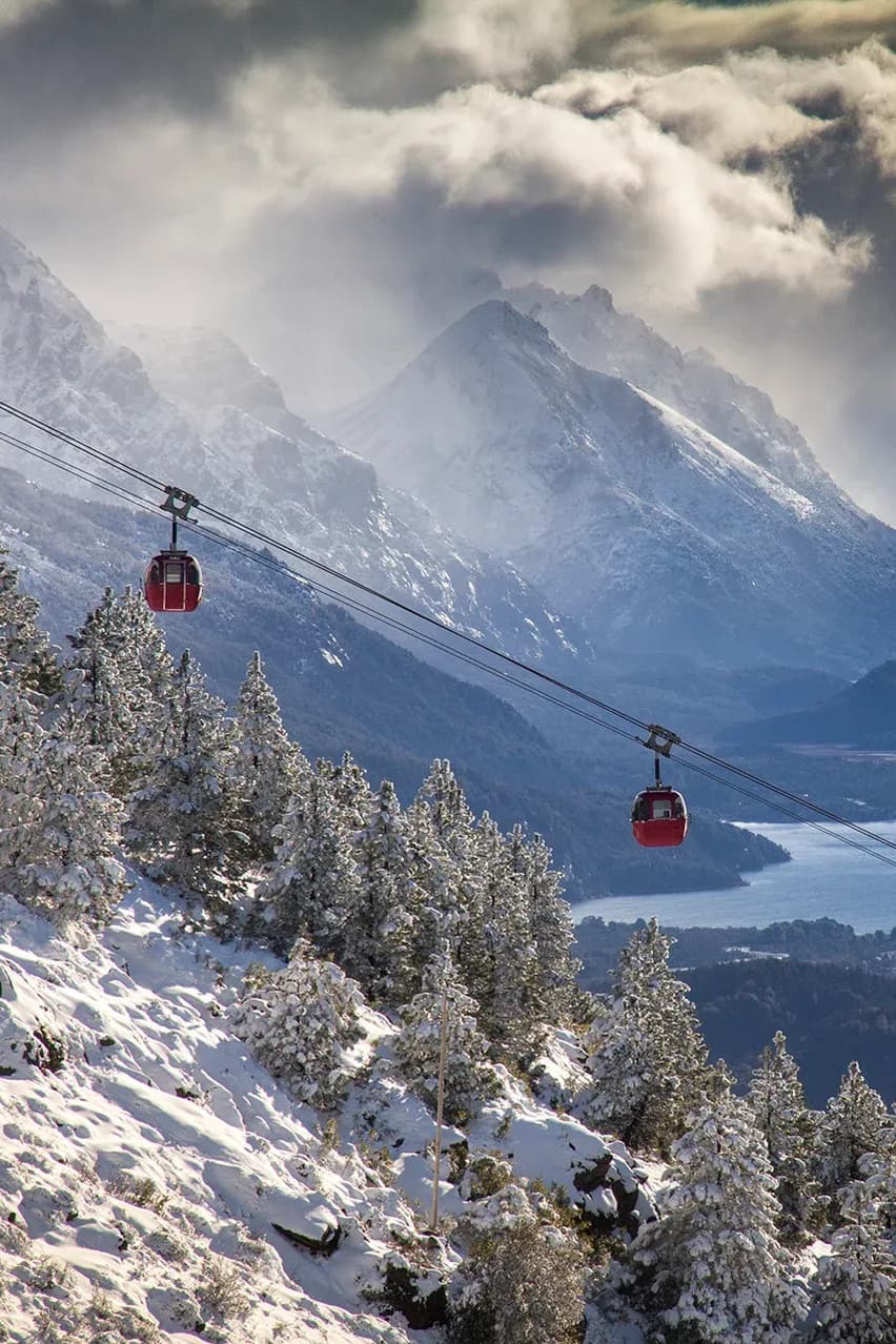 Two cable cars in motion with Lake Nahuel Huapi in the background