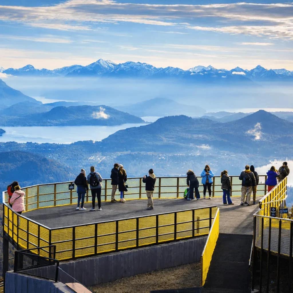 Mirante de Otto Hill com visitantes observando a paisagem de montanhas e lagos de Bariloche.