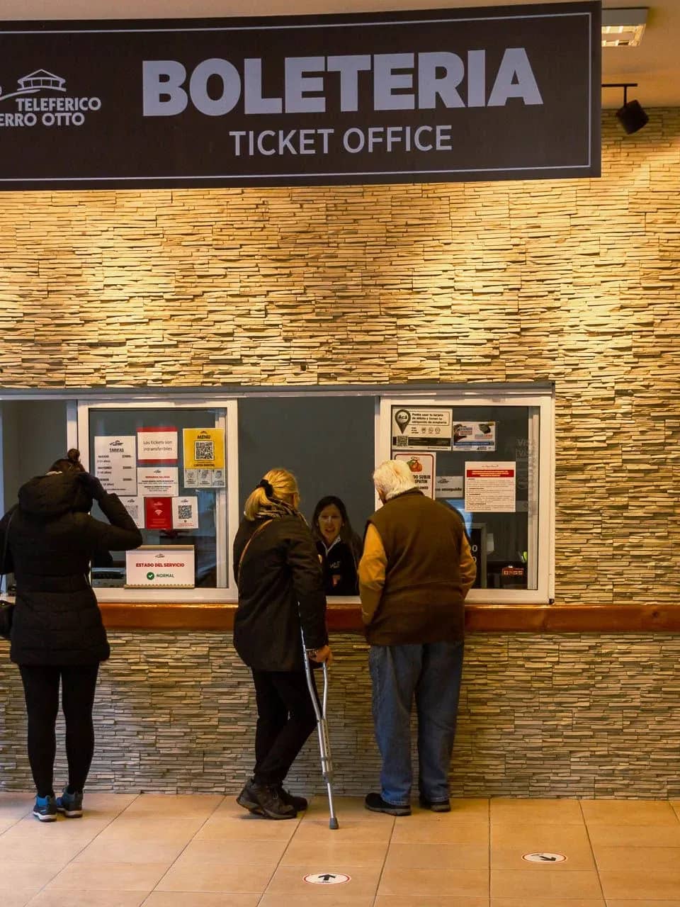 Bilheteria do teleférico Cerro Otto com pessoas comprando seus ingressos.